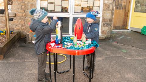 Young pupils playing with toy rockets