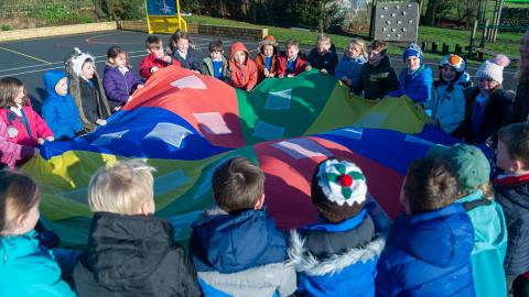Children in the playground, playing with a parachute
