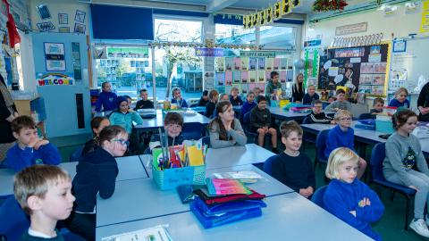 Children sat at their desks listening to a teacher